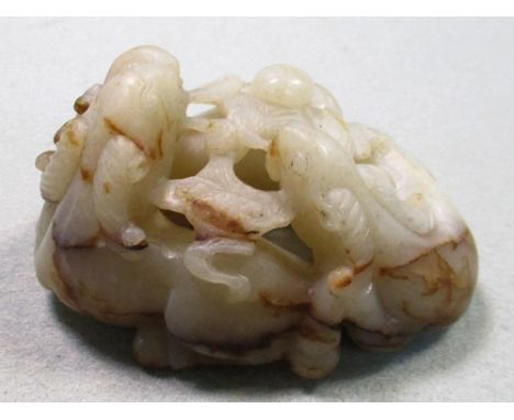 A white jade group of three goats, the stone with brown inclusions pierced and carved as three goats each with a stem of the 