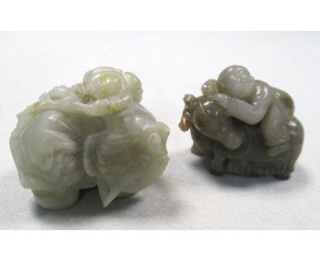Two jade groups of children riding an elephant and a deer, the first of smokey grey stone, the child on the pachyderm's back 