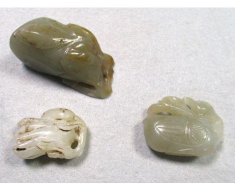 Three jade pendants, the largest of aubergine shape topped by foliage, 6cm (2.25 in) high, one carved as a duck with a foliag