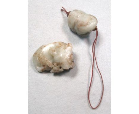 Two jade qilin/beast pendants, one reclining with a stem of cherry blossom in its mouth, 5.5cm (2.25 in) wide the other with 
