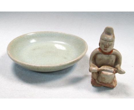 A Sawankhalok celadon figure and a celadon small dish, the seated figure playing a drum, 7.5cm (3 in) high, the dish with a c