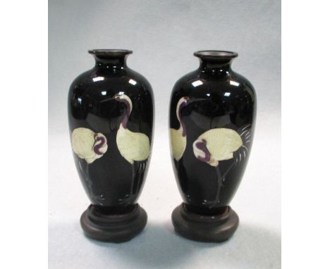 A pair of early 20th century cloisonne vases with wood stands. the midnight blue ovoid bodies with mirror images of pairs of 