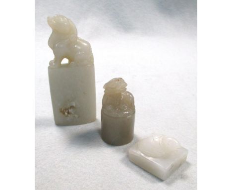 Three grey/green nephrite jade seals, the tallest of ellipsoidal section surmounted by a qilin, 8cm (3.25 in) high, the cylin