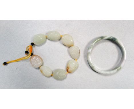 A jade eight pebble bracelet together with a Dushan stone bangle, each jade pebble carved on one side with Budai, the bangle 