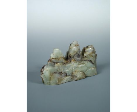 A jade three peak mountain brush rest, the dark brown inclusions in the pale green stone used to emphasize the blocks of rock