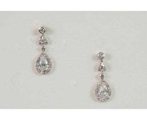 A PAIR OF DIAMOND DROP EARRINGS each set with a pear-shaped diamond drop within a surround of circular-cut diamonds, suspende