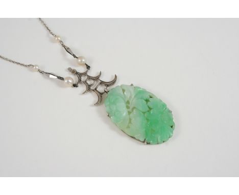 A JADE AND CULTURED PEARL PENDANT formed as an oval section of carved and pierced jade with white gold pagoda surmount and wi