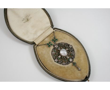 AN ARTS AND CRAFTS SILVER OPENWORK FOLIATE PENDANT centred with an oval blister pearl, the foliate surround is set with rock 