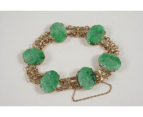 A JADE AND GOLD BRACELET the gold foliate link chain is mounted with six oval-shaped carved sections of jade, with concealed 