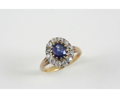 A SAPPHIRE AND DIAMOND CLUSTER RING the oval-shaped sapphire is set within a surround of old brilliant-cut diamonds, in gold.