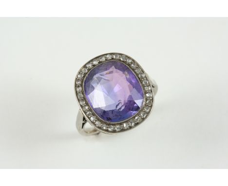 AN EARLY 20TH CENTURY SAPPHIRE AND DIAMOND RING the oval-shaped sapphire is set within a surround of rose-cut diamonds. With 