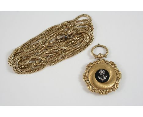 A VICTORIAN GOLD AND BLACK ENAMEL MOURNING LOCKET PENDANT the central panel of black enamel embossed with a flower set with r