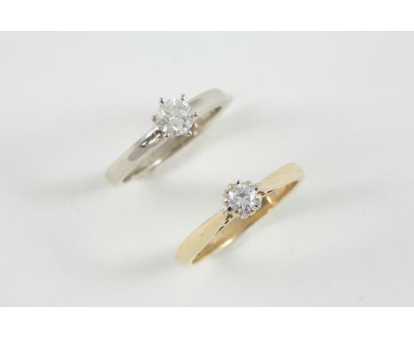 A DIAMOND SOLITAIRE RING the circular-cut diamond weighs 0.15 carats and is set in gold, size N, together with another diamon