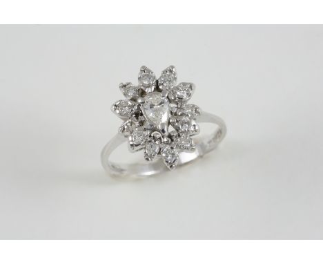 A DIAMOND CLUSTER RING the central pear-shaped diamond is set within a surround of circular-cut diamonds, in white gold. Size