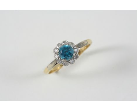 A BLUE ZIRCON AND DIAMOND CLUSTER RING the circular-cut zircon is set within a surround of single-cut diamonds, in 18ct. gold