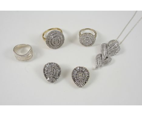 A DIAMOND CLUSTER RING centred with a circular-cut diamond within a surround of alternate baguette-cut and circular-cut diamo
