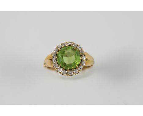 A PERIDOT AND DIAMOND CLUSTER RING the octagonal-shaped peridot is set within a surround of old brilliant-cut diamonds, in go