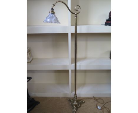 A brass standard reading lamp on a triform base 