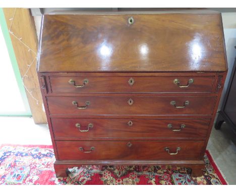 A Georgian mahogany bureau with a fall front and fitted interior over four drawers on bracket feet - Height 105cm x 100cm x 4