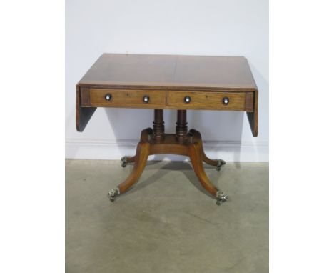 An early 19th century rosewood sofa table with satinwood banding, two active drawers and opposing dummy drawers on twin turne