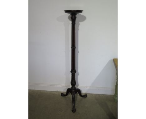 A mahogany torchere on a carved tripod base - Height 150cm