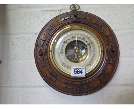 A carved walnut aneroid barometer