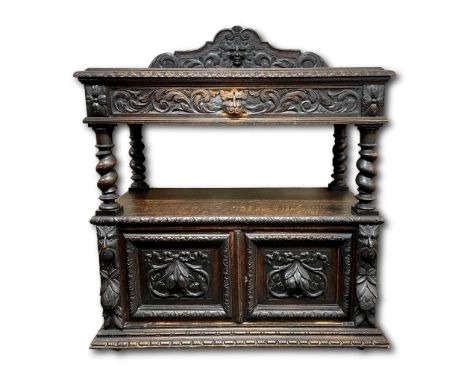 A Victorian carved oak buffet, the gallery with carved foliate scroll and mask, over a foliate moulded top with decorative fr