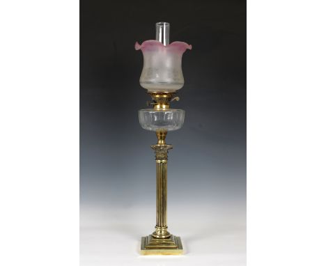 A Victorian brass Corinthian column oil lamp, with cut glass reservoir and pink to clear glass shade, raised on stepped squar