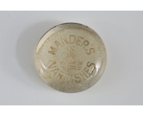 A clear glass advertising paperweight, early 20th century, for 'Mander's Varnishes', 8cm. diameter.