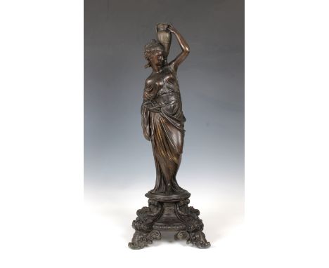 A decorative late 19th century metal candlestick, formed of a classical female figure on a four legged pedestal supporting an