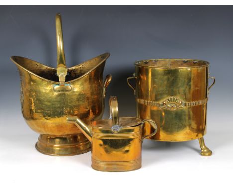 A Victorian brass helmet shaped coal scuttle, 36cm. wide, together with a small brass watering can, two brass coal buckets, o