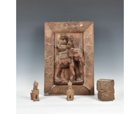An Indian carved wooden panel, first half 20th century, carved in high relief with an elephant mahout, within a foliate scrol