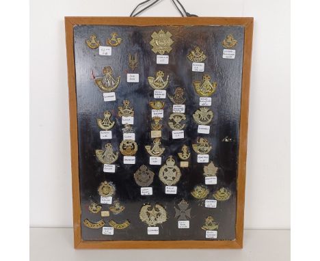 A frame of assorted military badges, including Somerset Light Infantry