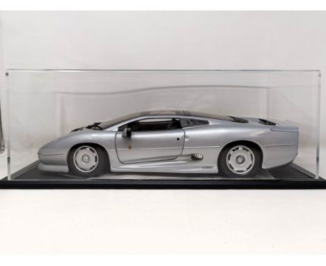 A Maisto 1:12 model of a Jaguar XJ220, in a display case