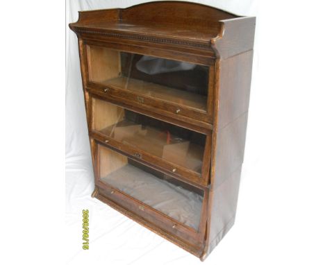 An early 20th century Globe-Wernicke-style oak-stained, three-tier stacking or barrister's bookcase with sliding glazed doors