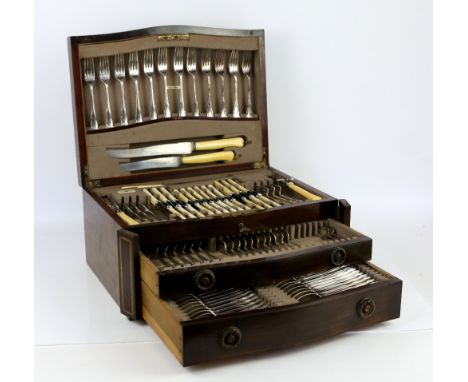 Mahogany serpentine fronted two drawer canteen of flatware for 12 place settings including carving set, knife rests, and soup