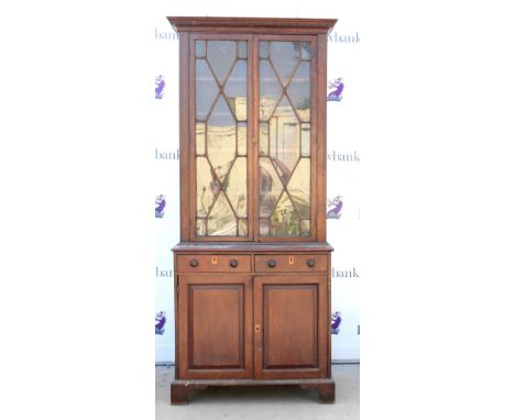 Early 20th century mahogany glazed bookcase, dentil cornice above astragal glazed door, two short drawers and two cupboard do