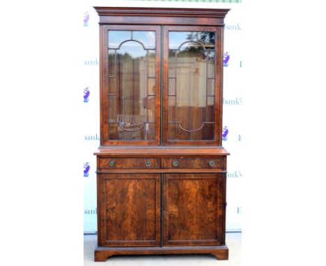 Early 20th century reproduction inlaid mahogany bookcase, dentil cornice above astragal glazed doors, two short drawers and t