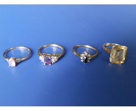 A rectangular cut citrine set 9ct ring and three other gem set 9ct rings. (4)