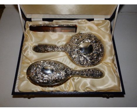 A cased modern embossed Birmingham silver three piece brush &amp; comb set in the Victorian style. (3)