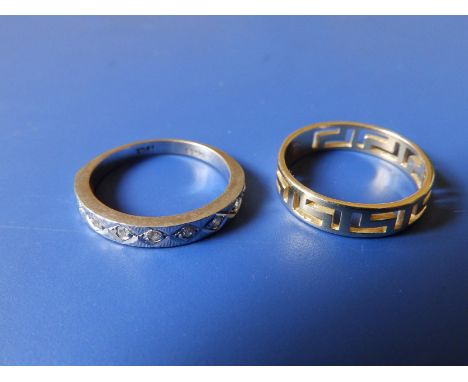 A white '18ct' half eternity ring with illusion set diamonds and a 585 band having pierced Greek key pattern. (2)