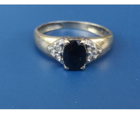 A modern sapphire &amp; diamond ring, the oval sapphire with six small diamonds to shoulders, on yellow metal shank.  Finger 