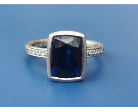 A boxed Malcolm Betts certified  2.98 carat sapphire &amp; diamond ring, the collet set rectangular cushion cut sapphire rais