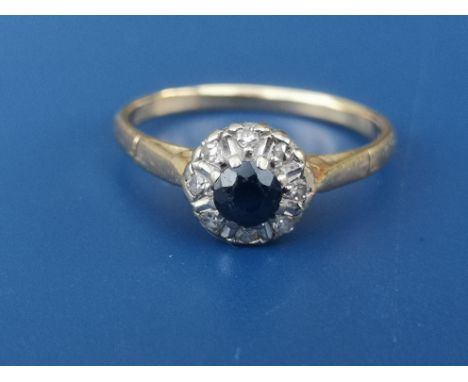 A small sapphire &amp; diamond circular cluster ring on yellow metal shank.  Finger size O.