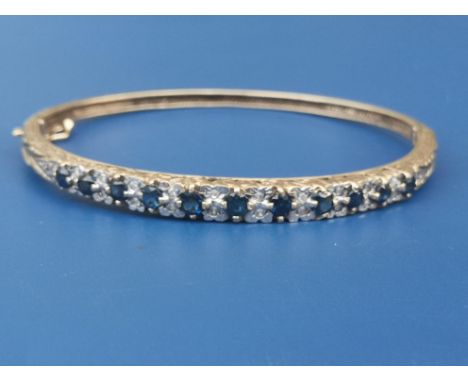 A sapphire &amp; diamond set 9ct gold bangle, maximum internal dimension 2.25".