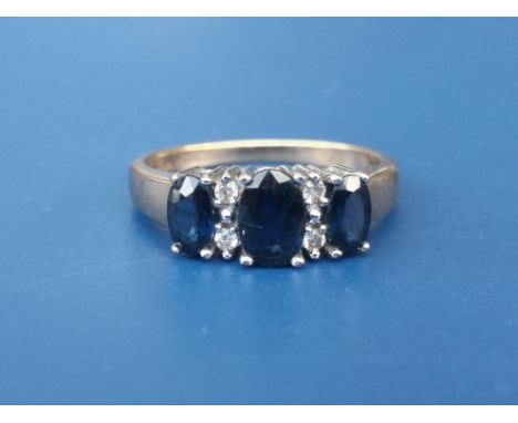 A modern three stone sapphire ring with four small diamonds on 9ct gold shank.  Finger size K and a 9ct white gold wedding ri