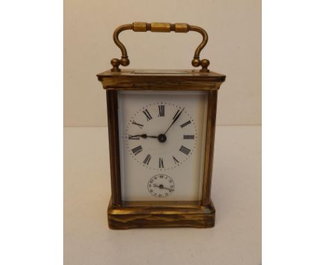 A brass cased alarm carriage clock with white enamel dial, 4" high excluding handle.