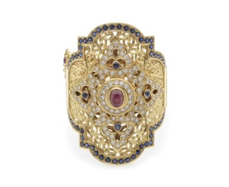 BRACELET MANCHETTE SAPHIRS, RUBIS ET DIAMANTSOrné au centre d'un cabochon de rubis, ajouré de motifs orientaux sertis de quat