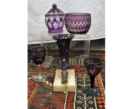 A collection of amethyst and amethyst overlaid cut glass ware including two cornucopia vases, four rinsers, lidded jar, ten a