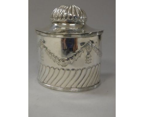 An Edwardian silver oval tea caddy, the domed hinged cover with gadrooned finial opening to reveal a provision for caddy spoo
